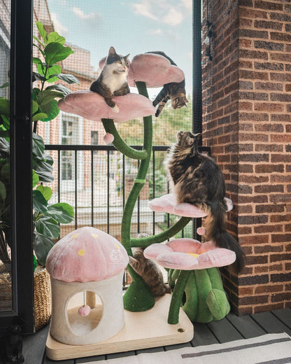 A cat happily plays on a cat tree adorned with a pink flower